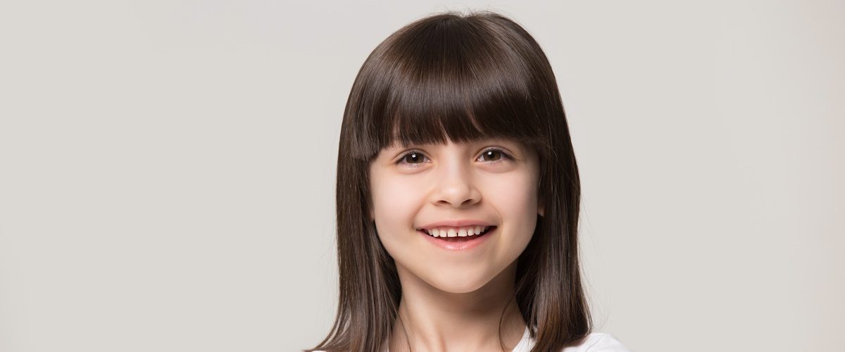 AdobeStock_296065406 Close up headshot portrait of smiling little girl isolated on grey studio background look at camera, happy small preschooler child in white t-shirt posing feel overjoyed excited show healthy teeth SSUCv3H4sIAAAAAAAACoxSzY7TMBB+leIbUoPy6zY9c+UJ2j1MbKcx68SR7fCjqhJajhzgiEBaafcJKrESC6g8g/tGjNOuENUeOLQaf/N9M5NvZkMqsJKRxYZIpQbrDDipO7KIp8SIjgszhoJLp40ENb4qcKzpoBVk0Q1KbafEOnCDFTbUsc3gnDDWaXZJFglmGTixRvkxf2q43AScLAhB+VCFYDt9BLuYEliLjr0NWlDQYrAkGaN0PocqqmeMRTmr42hOqYjKJMGMSOOqjrHIf9GwQyXX47x9o50O9VH7QlomlIJO6MEGEhe9ttKNHHsipXTMGAGtdTI4siRJUmImoWn4L8pA+NeTozIlF1s0xwglYLRuSeqaz6Cu0ygGyKOccxaVXJRRllNW1zEXOc9DucvXWKwNbmIBGLjEmTfklWagEMwQ7I1kslsfGdo1YY9orh46Z9DAMIDSuodK4cg1ysSUNGAtEvgJCIvDg9DtsUinXRgyKDnuE6MkS5OCxnM6S0uaxkVRkIdLaCQKQ6MNGXqlgQv+yGkUsyTJ8iwtgg8jKPnpoyTyCWWzKs1KiARk8ygviiwCWtRRWcRz9IYWVCTY8tgh7A0PhOtKPNRH+9PM1GN0tmFEztaJCIPujNPrjhfHnFZ6MJV+M75Od4hRq+3fEjh4rU07nrABi586+oxr6cE1CD5frFZPJv7G3/pr/8V/Xq389eGdv/ff8Lf3O//r8AGxm8PV4b2/Q+yH/+l3q1USP534r/j+7ncTfz/xn/z+cOV/+z2yb1G3P3xE1rOX/Zps/wAAAP//AwAgR7fa1AMAAA==